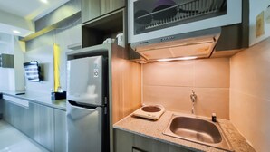 Una cocina moderna con electrodomésticos de acero inoxidable, horno empotrado y un espacio compacto para el lavamanos.