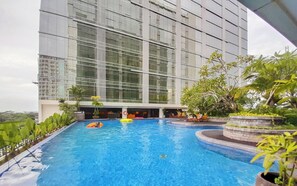 Ein Schwimmbad mit Blick auf ein modernes Gebäude mit großen Fenstern.
