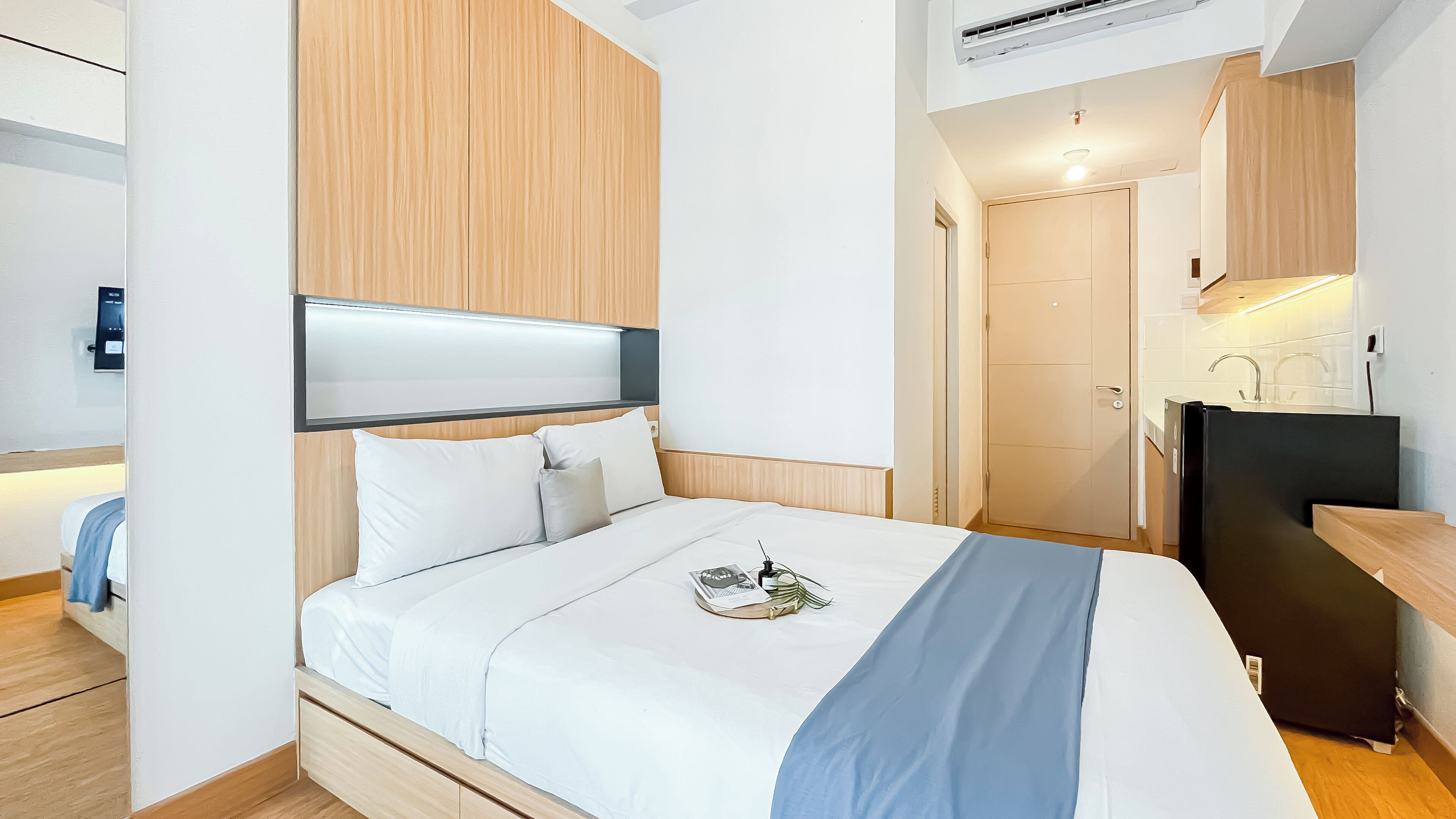 Une chambre d’hôtel moderne équipée d’un lit, d’un bureau et d’une kitchenette.