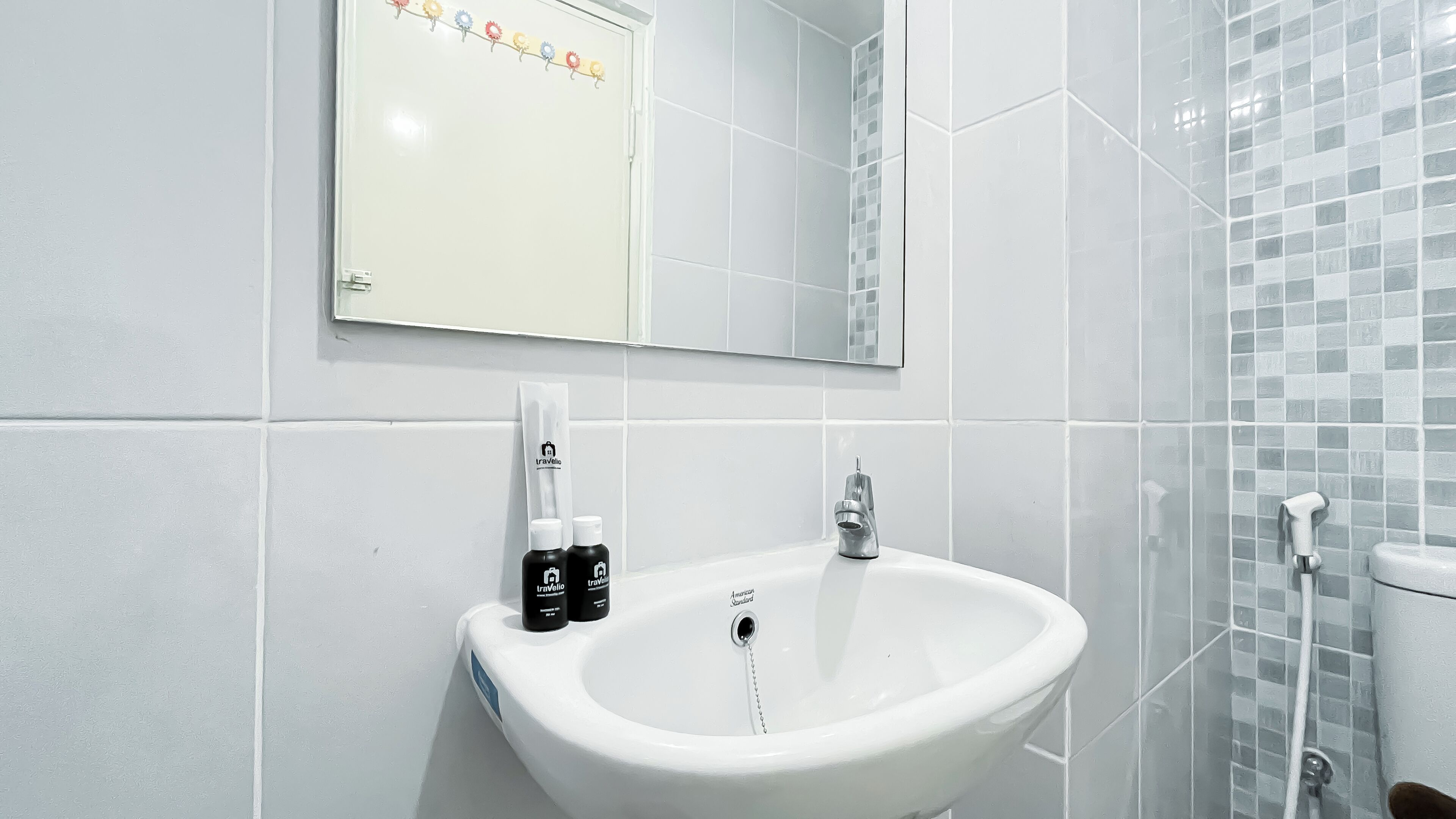 A bathroom with a white sink, a mirror, and a shower area.