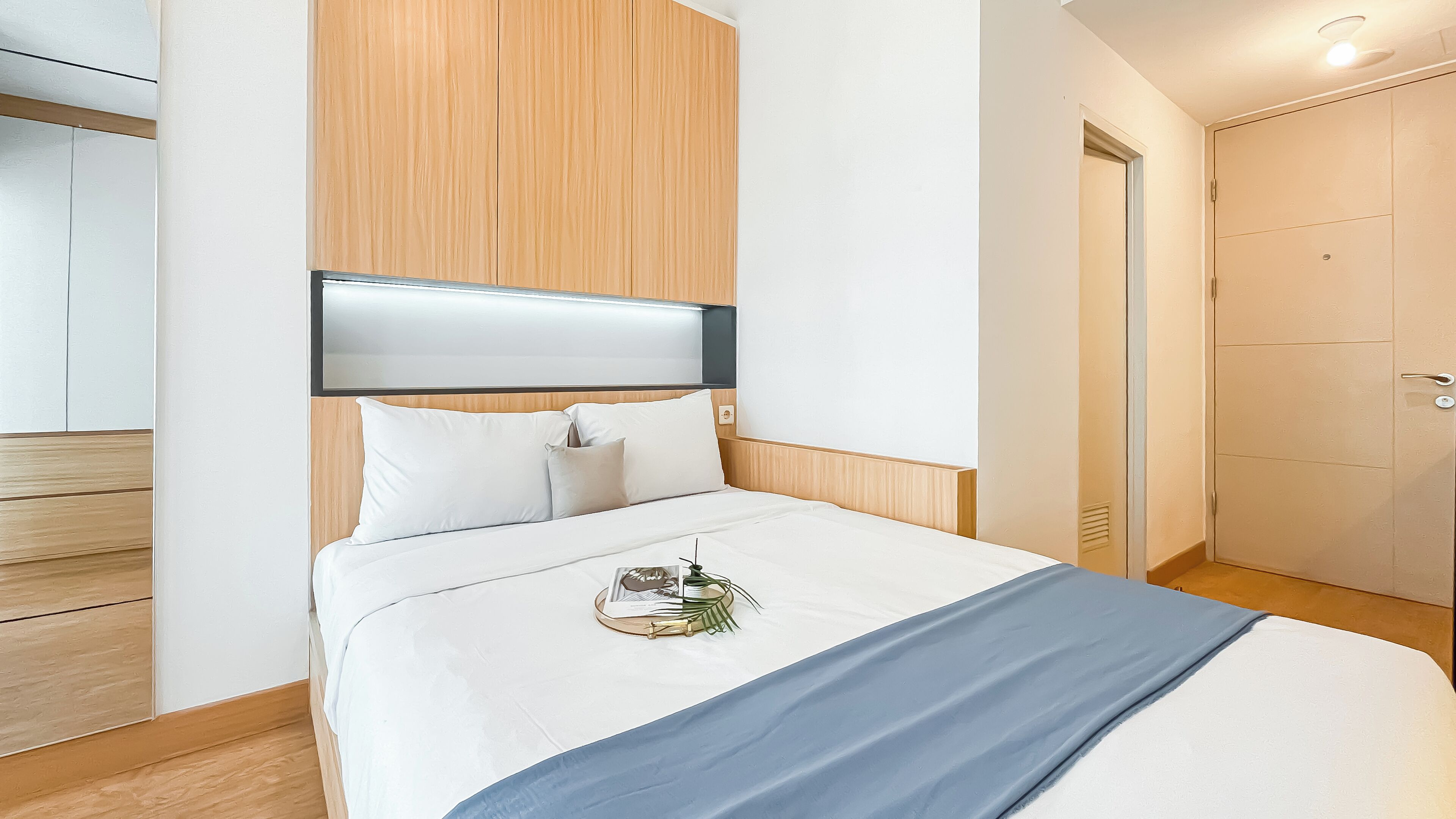 Ein Hotelzimmer mit Bett, Nachttisch, Lampe und Kleiderschrank.