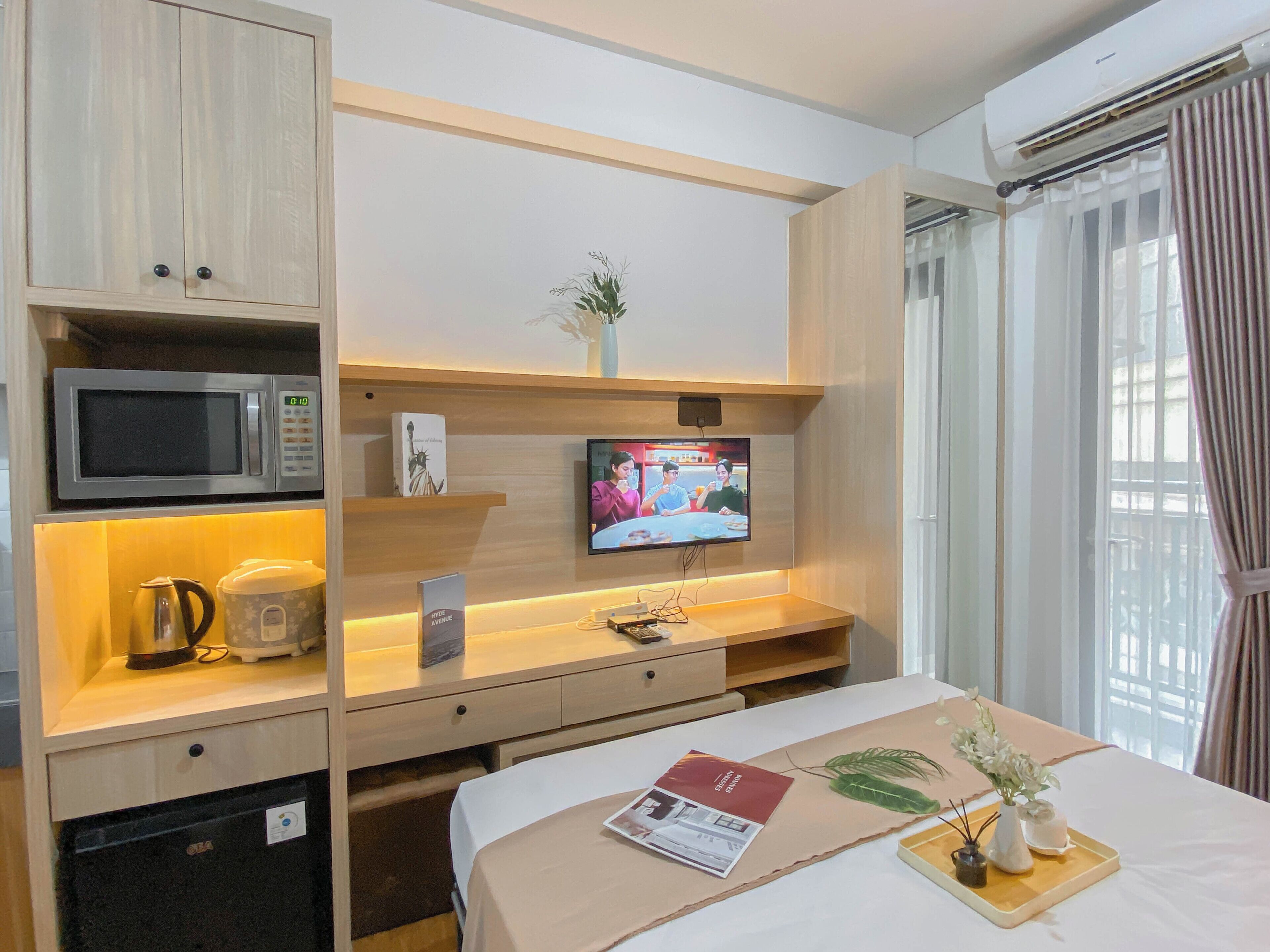 A hotel room with a bed, a TV, a microwave, and a coffee maker.