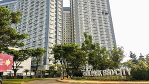 A high-rise residential building with multiple balconies and a sign indicating 'PARK BLDG CITY'.