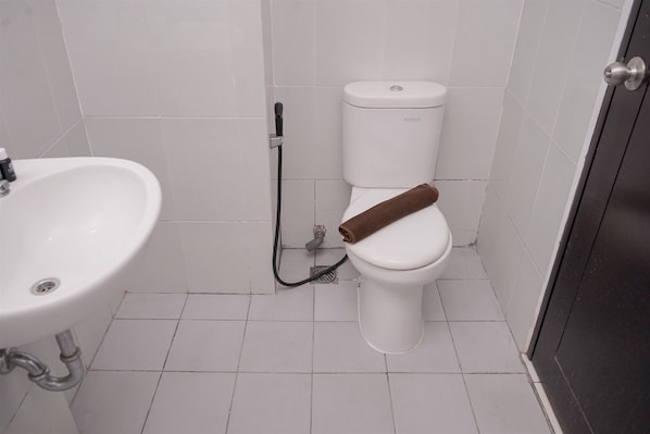 Un baño con lavamanos, inodoro y ducha blancos.