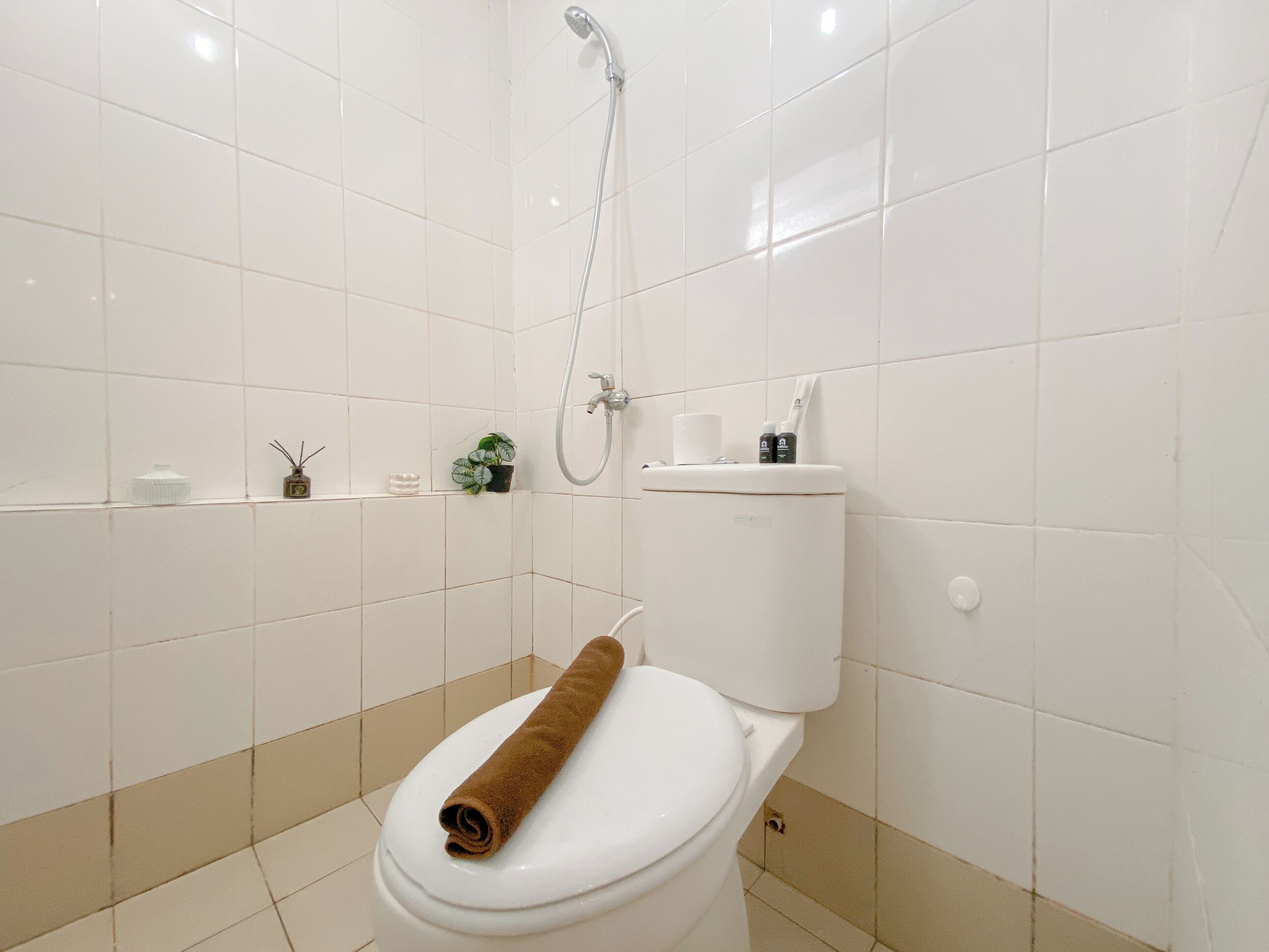 A bathroom with a white toilet, a shower, and a sink.