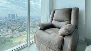 Ein modernes Wohnzimmer mit einem großen Fenster und Blick auf die Stadt.