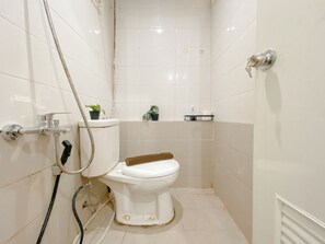 A small, clean bathroom with a toilet, a shower, and a sink. - Comfy 1BR Apartment with Extra Room at Green Pramuka City near Mall (Jakarta)