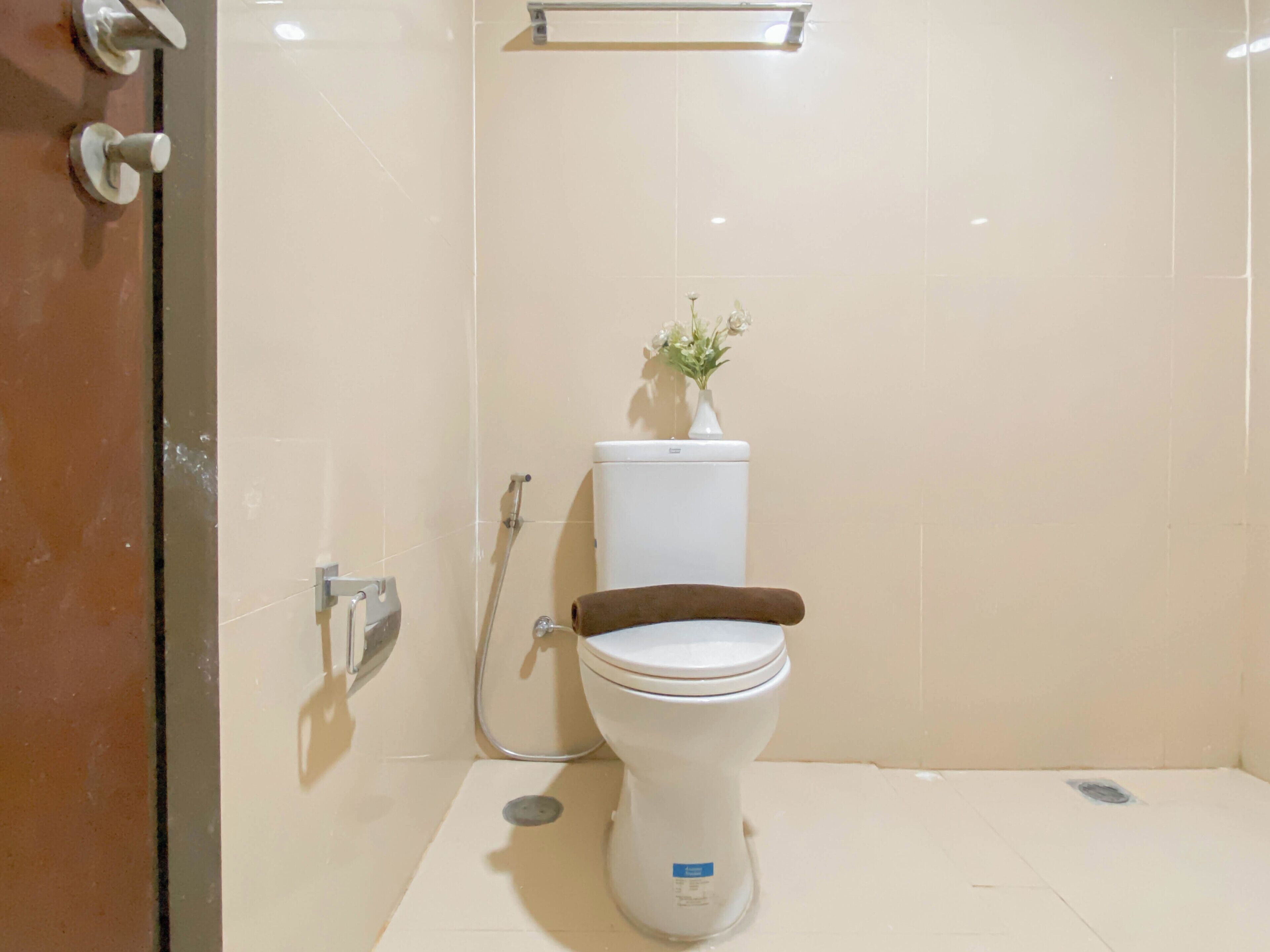 A bathroom with a toilet, a shower, and a glass door.