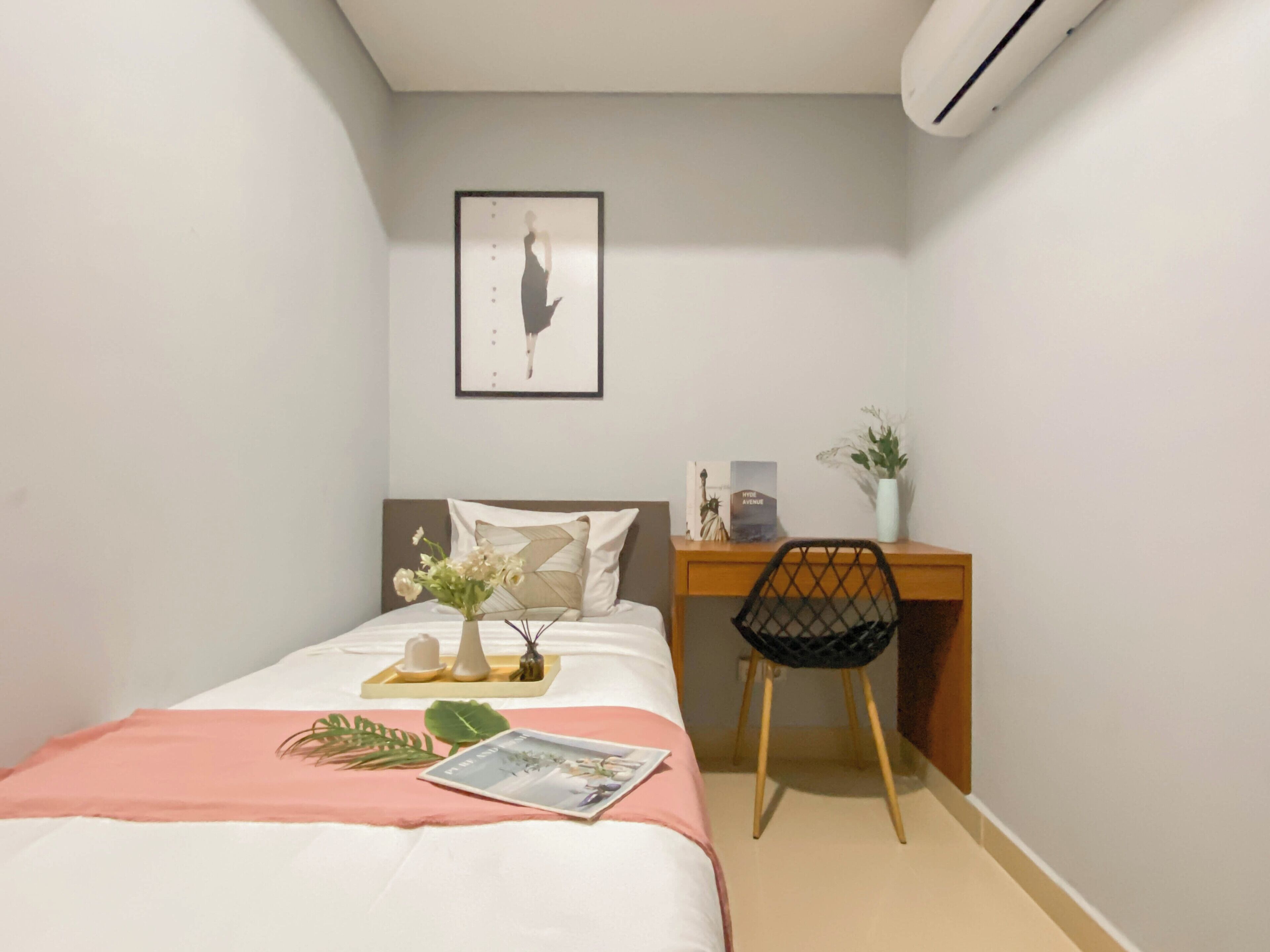 Un dormitorio ordenado con una cama, un escritorio y una silla.