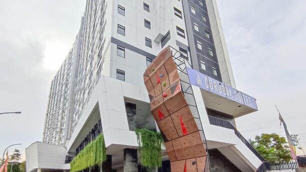 Un edificio moderno con un diseño angular distintivo, que muestra un letrero que dice 'CORDOVA SUITES'.