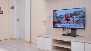 A television mounted on a wall displaying a news broadcast.
