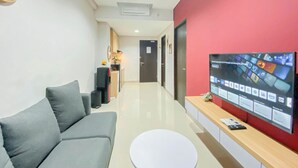 Ein modernes Wohnzimmer mit grauem Sofa, einem weißen Couchtisch und einer roten Akzentwand.