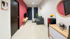 Ein modernes Wohnzimmer mit einer Couch, einem Couchtisch und einem Fernseher auf einem Schrank.