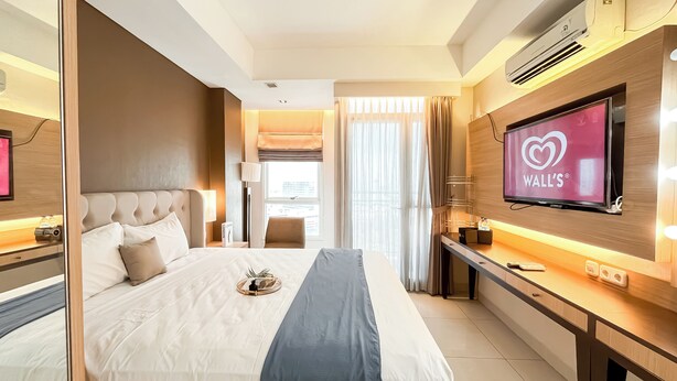 Ein modernes Hotelzimmer mit einem großen Bett, einem Schreibtisch, einem Flachbildfernseher und Blick auf die Stadt.