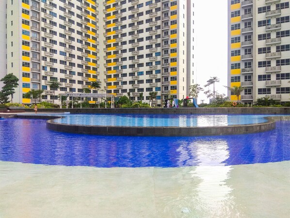 Enjoy a refreshing swim in the pool surrounded by a paved area and take in the views from the building's balconies.