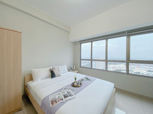 Relax in a spacious room with a large bed and city views through the multi-paned window.
