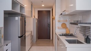 A modern kitchen with white cabinetry, a built-in oven, and a stainless steel sink.