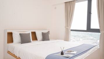 Enjoy a peaceful retreat with a single bed, a small table, and a large window offering a city view.