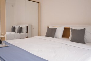 Un dormitorio con cama, mesita de noche y espejo.