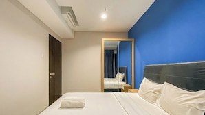 A hotel room with a bed, a nightstand, a mirror, and a door. - Best Deal 1BR Corner at Patraland Amarta Apartment (Ngaglik)