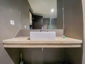 A modern bathroom with a large rectangular sink, a mirror, and a shower area. - Best Deal 1BR Corner at Patraland Amarta Apartment (Ngaglik)
