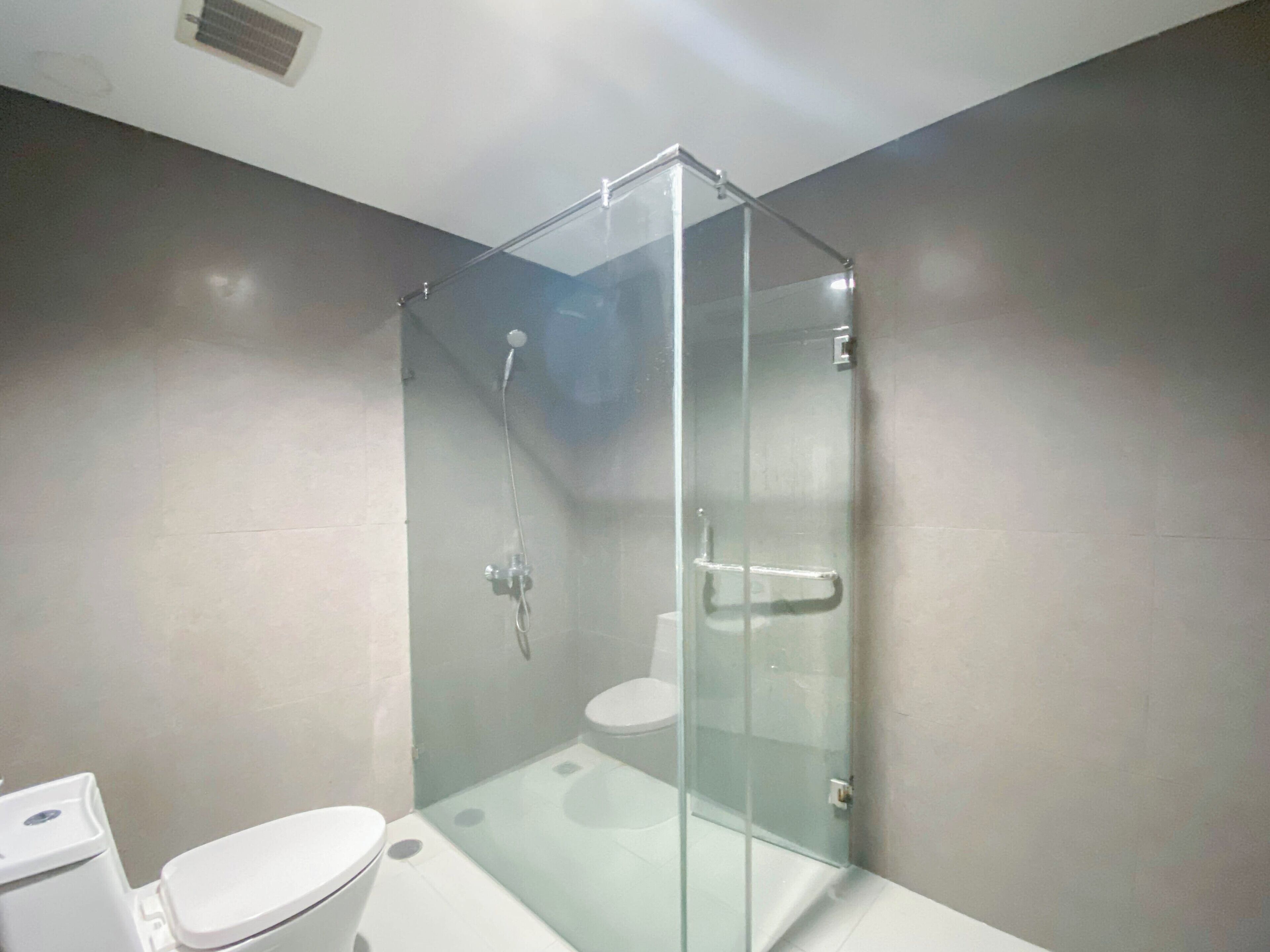 Une salle de bain moderne avec une douche à parois de verre, des toilettes et un lavabo.