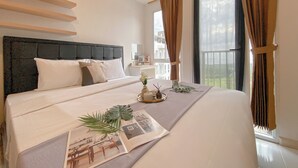 Ένα σύγχρονο υπνοδωμάτιο με ένα μεγάλο κρεβάτι, ένα προσκέφαλο και θέα σε ένα μπαλκόνι.
