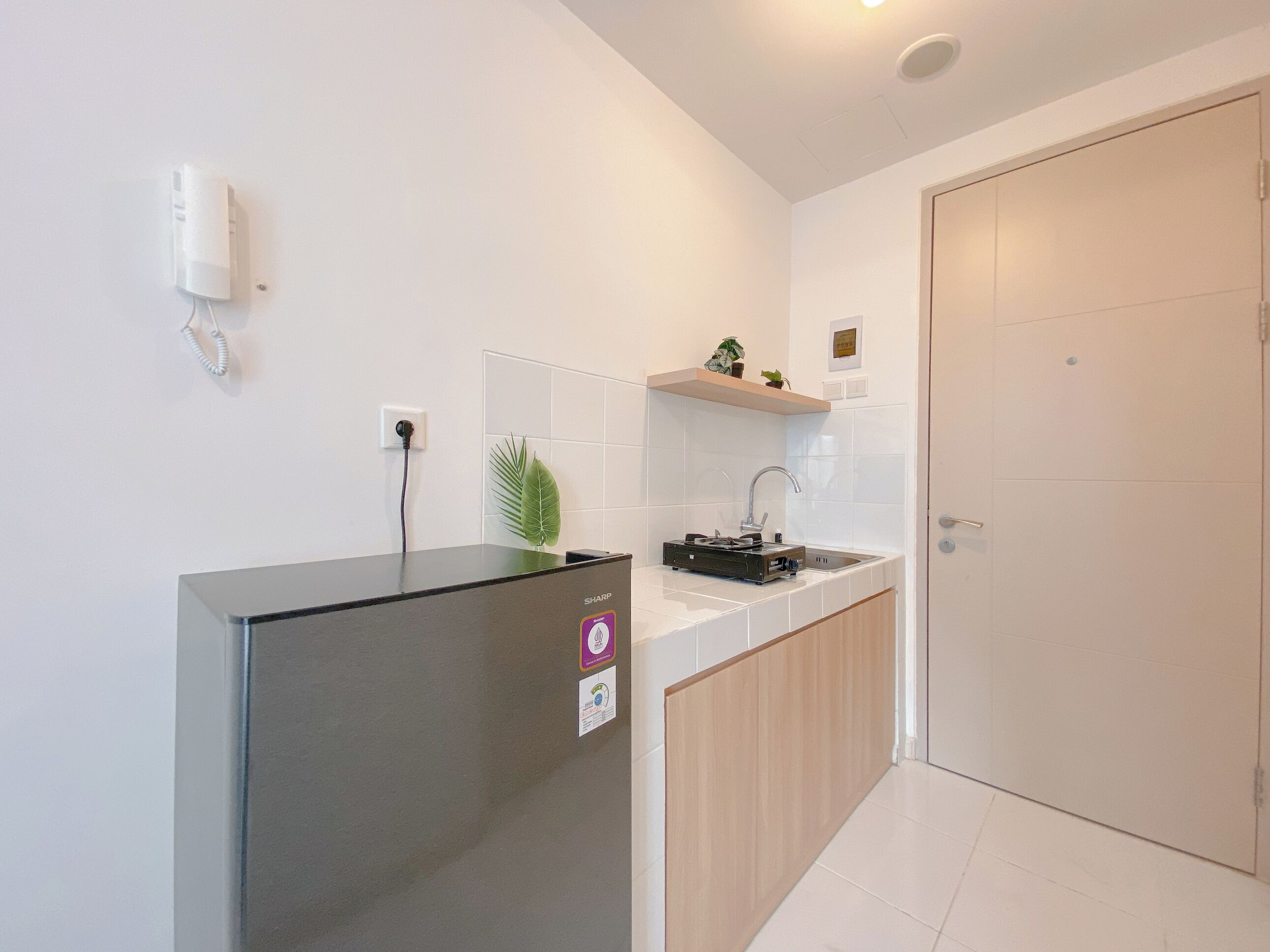 A compact kitchen with a refrigerator, a sink, and a small countertop.