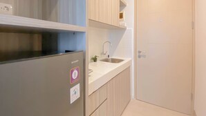 Eine Küche mit einem Edelstahl-Kühlschrank, einer Spüle und Holzschränken.