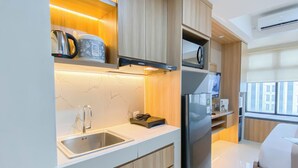 A modern kitchen with a stainless steel sink, a built-in oven, and a microwave.