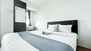 Une chambre d’hôtel moderne, dotée d’un grand lit, d’un bureau et d’une chaise.