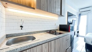 Une cuisine moderne dotée d’un plan de travail en granit, d’un évier en acier inoxydable et de meubles en bois.