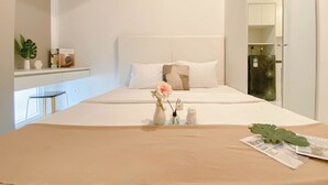 Ein ordentlich eingerichtetes Schlafzimmer mit einem Bett, einem Nachttisch und einer kleinen Pflanze.