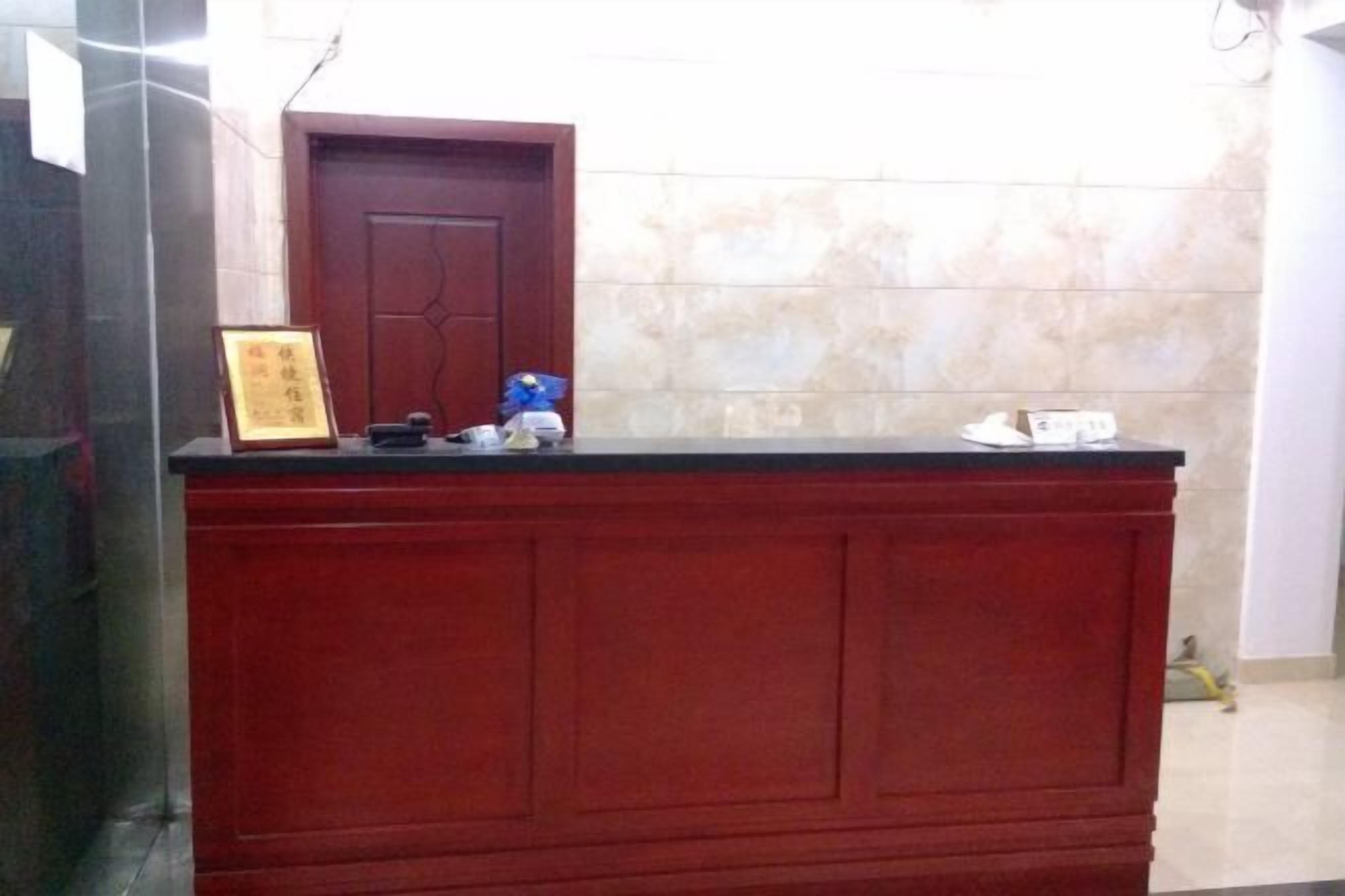 A reception desk with a framed certificate, a blue item, and a white object on it.