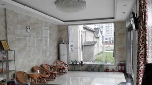 A modern hotel room with a large window, a reception desk, wicker chairs, and a small table. - YangZhou FuRun Hotel (Yangzhou)