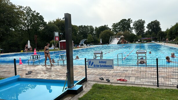 A swimming pool with lane markers, a lifeguard stand, and a small kiddie pool.