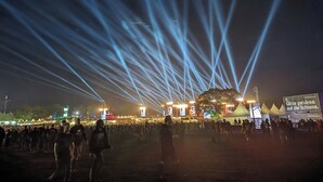 A large outdoor event with a crowd and illuminated structures.
