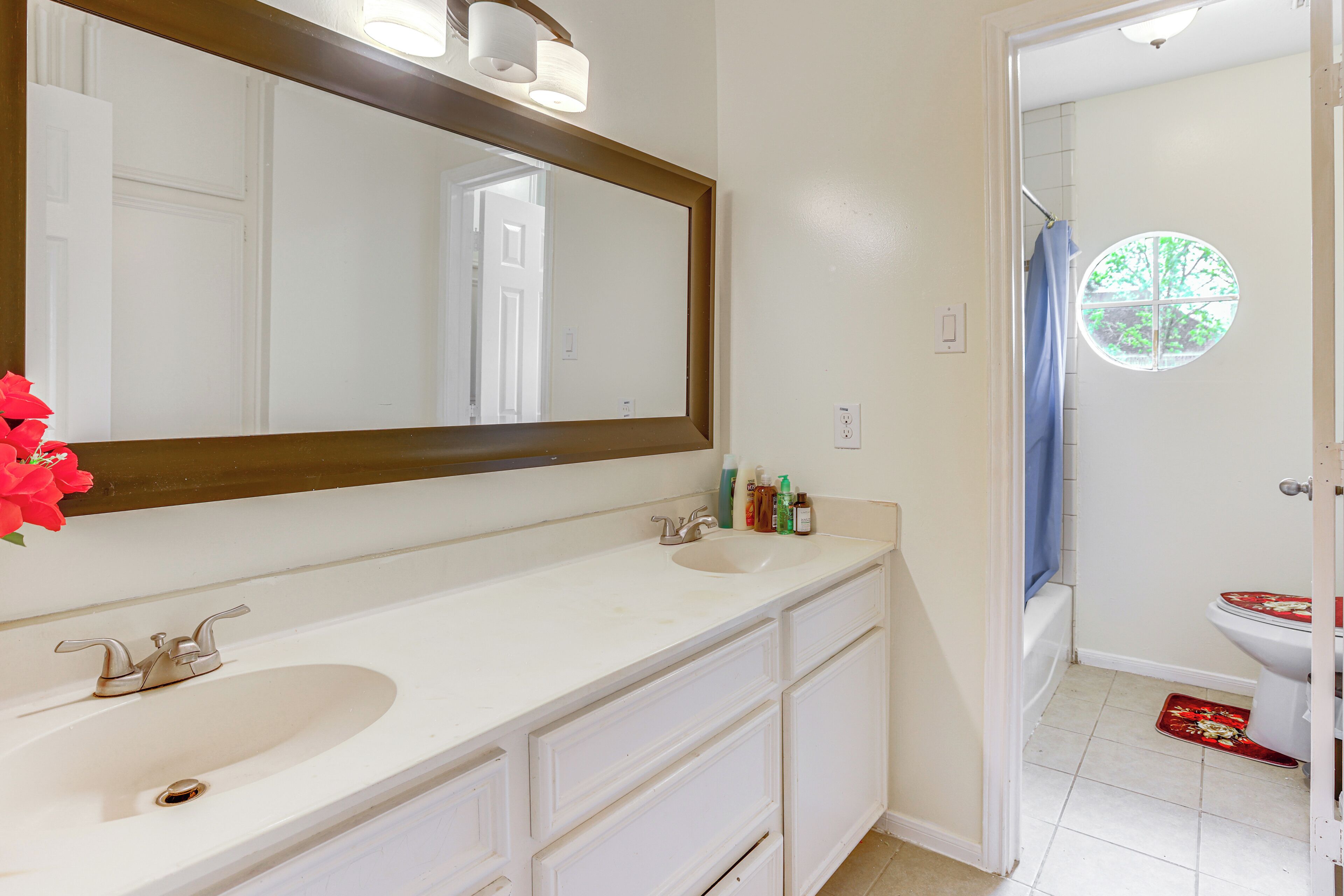 A bathroom with two sinks, a large mirror, and a toilet.
