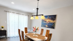 Un'area pranzo con un tavolo di legno, sedie e un quadro appeso al muro.