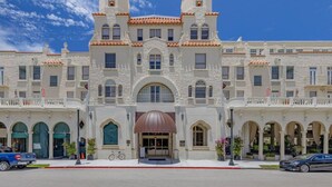 A large, white building with a symmetrical facade, multiple windows, and a central entrance with a brown awning. - Palm Beach Regency Walk to Beach (Palm Beach)