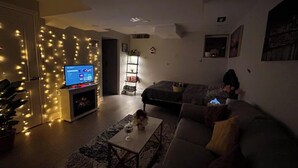 A living room with a television, sofa, and a bookshelf. - Private Studio- Cozy, Comfort,Convenience (Milton)