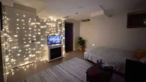 A modern bedroom with a bed, a TV, and a decorative light wall. - Private Studio- Cozy, Comfort,Convenience (Milton)