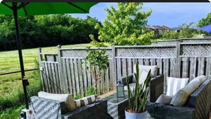 An outdoor patio area with wicker furniture, a small round table, and a potted plant. - Private Studio- Cozy, Comfort,Convenience (Milton)