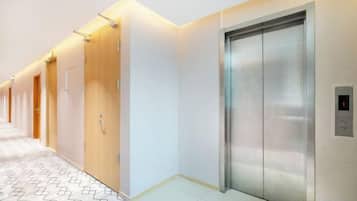A hallway with doors and an elevator.