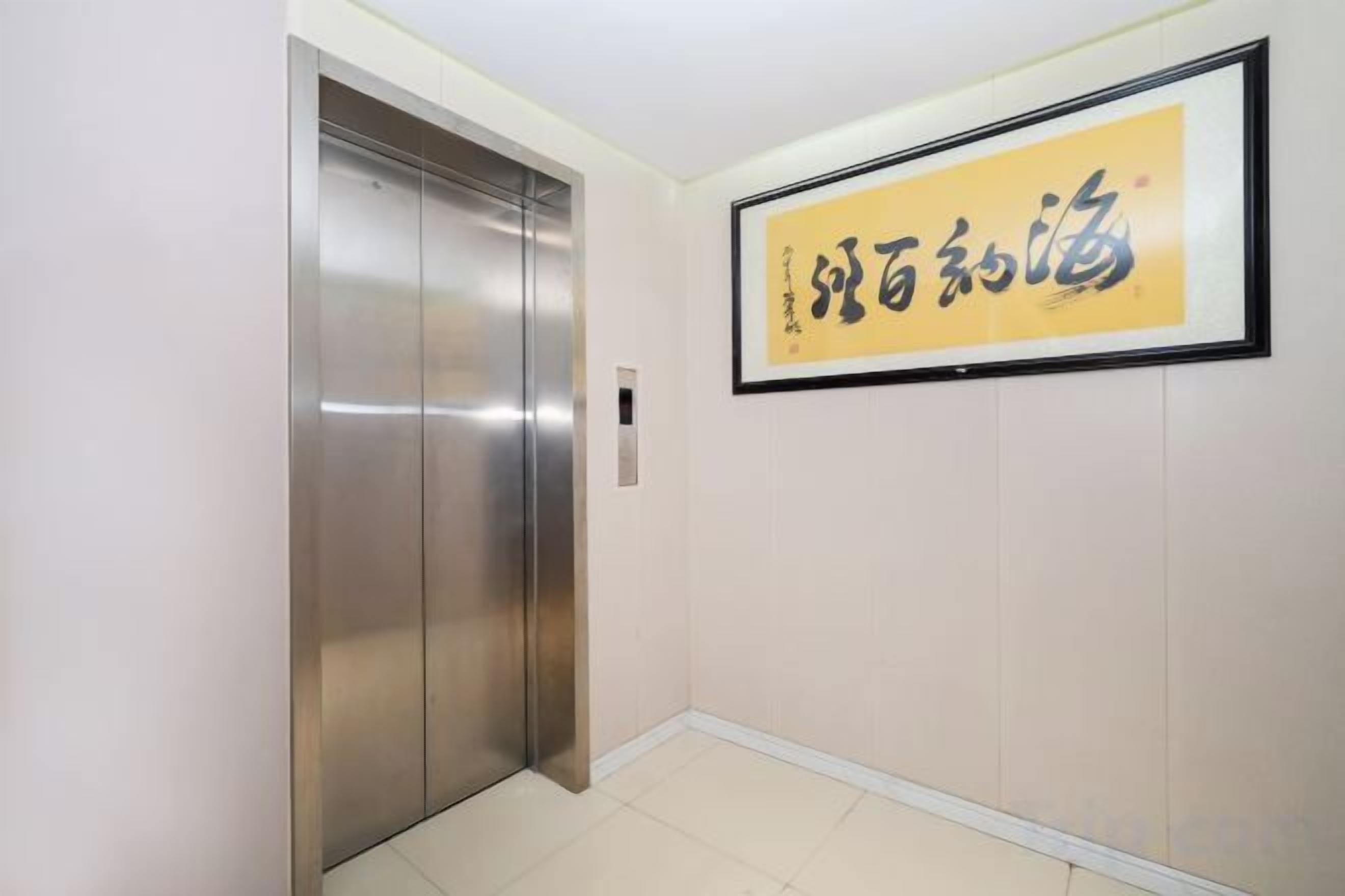 An elevator in a hallway with a framed sign on the wall.