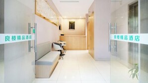 Un moderno vestíbulo de hotel con mostrador de recepción, zona de estar y un panel de vidrio.