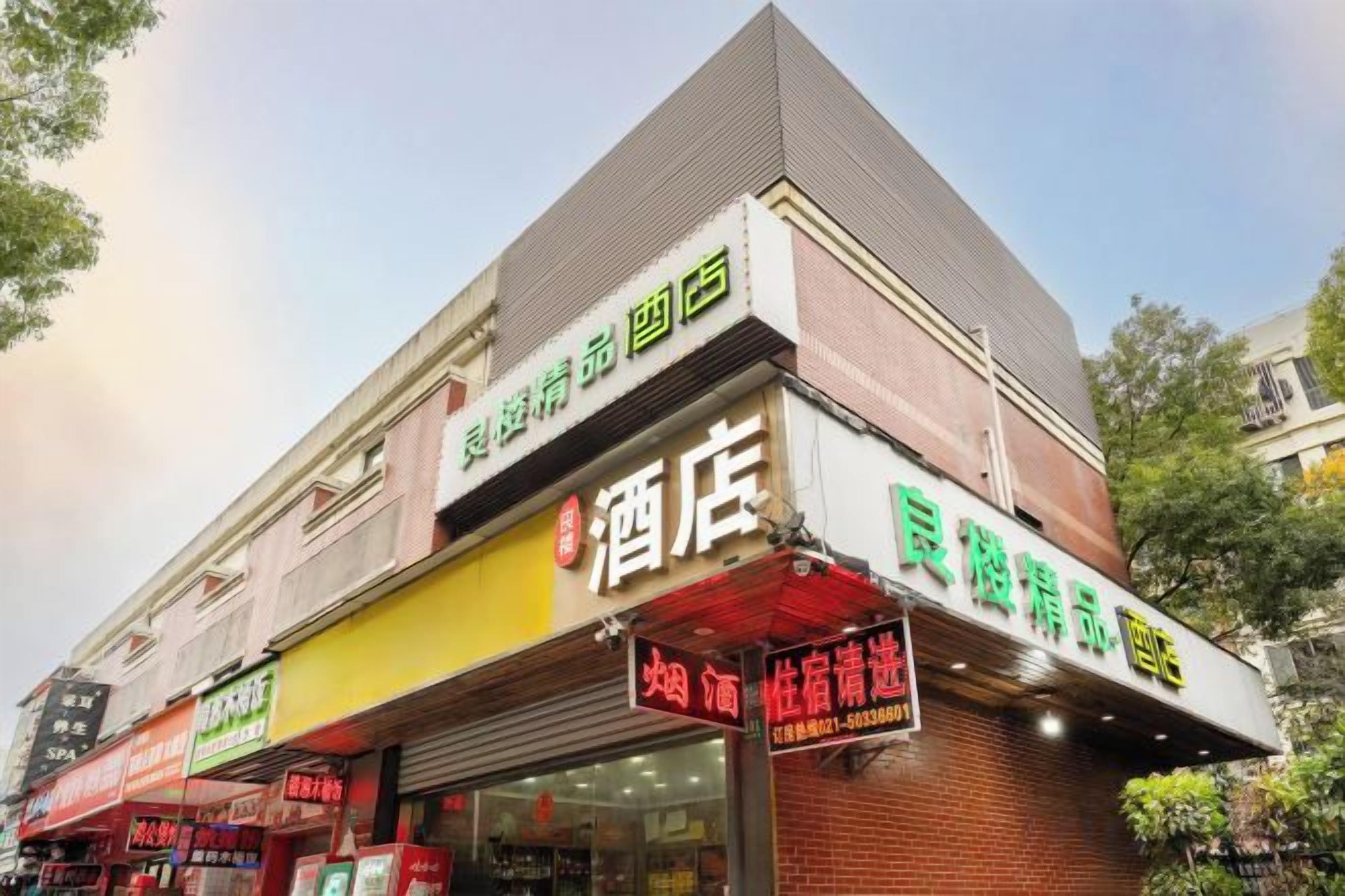 A hotel with a prominent sign, multiple storefronts, and a brick facade.