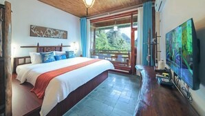A bedroom with a large bed, a television, and a view of a mountain.