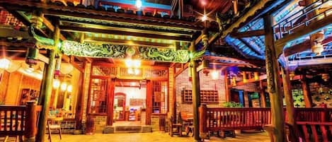 A traditional building with a wooden facade, a covered entrance, and a staircase leading to the entrance.