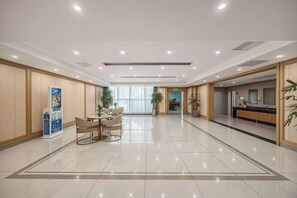 A hotel lobby with a reception desk, a seating area, and a large window. - Hangzhou Yuecheng Audio & Video International Hotel (Boao Xinhan Road Subway Station) (Hangzhou)